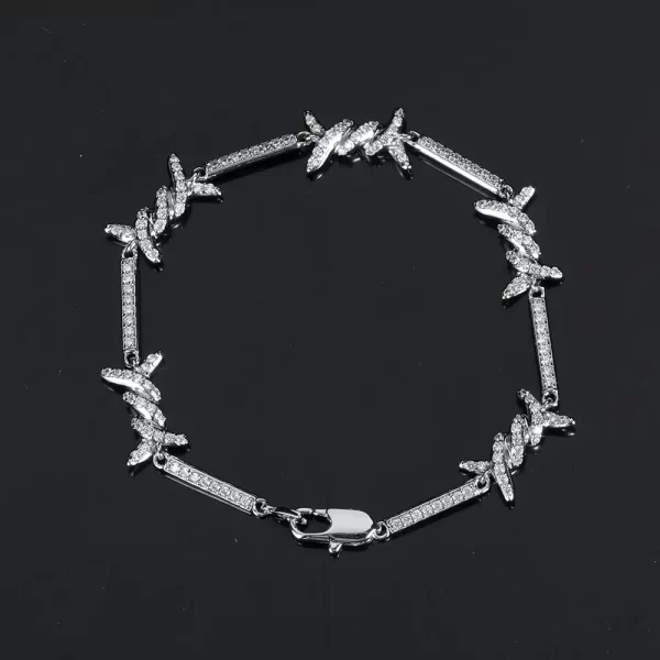 The Iced Thorns Bracelet in White Gold - 3mm offers a sleek yet bold look for Hip Hop enthusiasts. With thorn-inspired accents and prong-set VVS Simulated Diamonds, this bracelet shines with an edgy elegance. The White Gold finish ensures both durability and a polished, luxurious appearance. Perfect for layering or wearing solo, this 3mm bracelet brings versatility and sophistication to any outfit, making it an ideal choice for those who want to make a subtle statement with their jewelry.