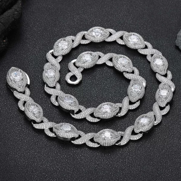 Turn heads with the Iced Infinite Eyes 8-Shaped Link Chain in White Gold. This 15mm chain features a distinctive 8-shaped design, intricately set with VVS Simulated Diamonds for a brilliant shine. The White Gold plating adds a sleek, modern twist to this bold piece, making it a versatile accessory for any occasion. Whether paired with streetwear or formal attire, the White Gold finish offers an elegant contrast that makes the chain stand out in any setting.