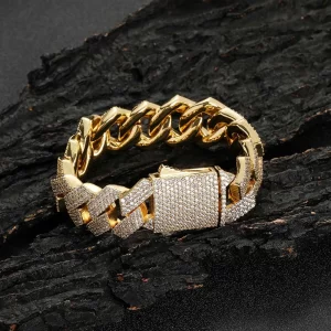 The Iced Diamond Miami Cuban Link Bracelet - 19mm offers unmatched shine and luxury. Featuring prong-set VVS Simulated Diamonds in a 19mm Cuban link, this bracelet delivers an exceptional iced-out look. The Yellow Gold Plating adds a touch of class and durability, making it a must-have for anyone who loves to stand out with bold accessories. Perfect for Hip Hop fans who appreciate oversized jewelry, this bracelet is designed to make a statement at any event or as an everyday showpiece.