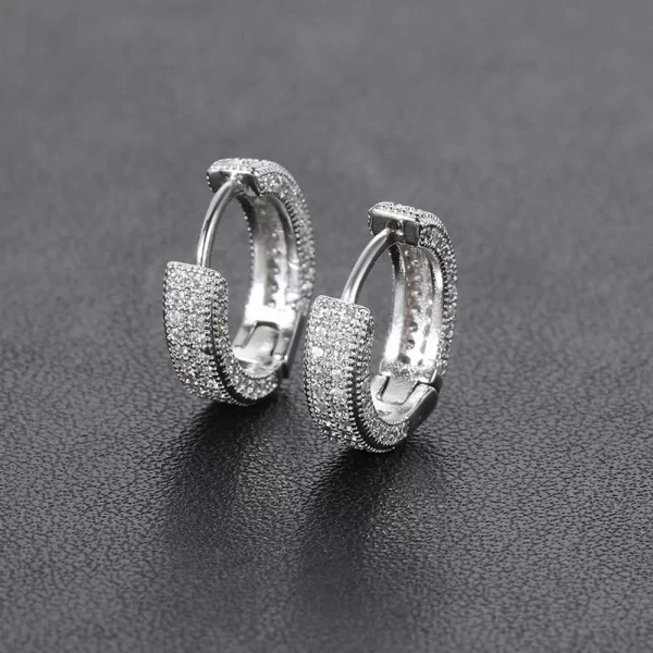 The 2 Layer Iced Hoop Earrings in White Gold offer a sleek, modern look with two layers of simulated diamonds for maximum shine. With an 11mm size and White Gold-plated finish, these hoops provide both durability and elegance, making them the perfect accessory for anyone looking to elevate their Hip Hop-inspired style.