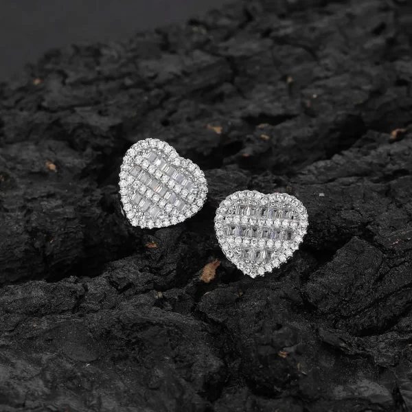 The Iced Heart Stud Earrings in White Gold are designed for those who love to combine Hip Hop bling with elegance. The heart shape, paired with a White Gold-plated finish and sparkling simulated diamonds, creates a perfect blend of romance and style. Ideal for adding a touch of luxury to any outfit, these earrings are versatile enough for any occasion.