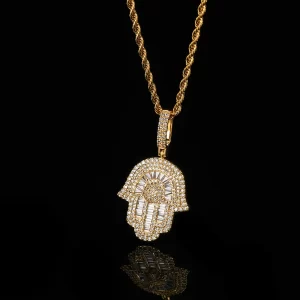 The Hamsah Hand Pendant in Yellow Gold is a 28mm symbol of protection and good fortune, elegantly designed with VVS simulated diamonds. The Yellow Gold plating gives it a luxurious and eye-catching shine, perfect for adding a touch of bling to your casual or formal outfits. Hypoallergenic, waterproof, and scratch-resistant, this pendant is built to last while maintaining its bold and polished look. Whether worn solo or layered with other pieces, the Hamsah Hand Pendant brings both style and spiritual significance, making it a must-have for those who appreciate Hip-Hop culture with a touch of tradition.