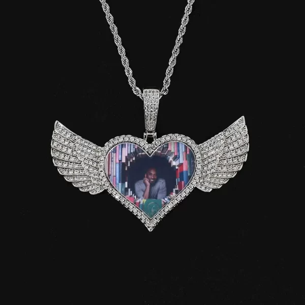 The White Gold Custom Angel Wing Heart Pendant brings a timeless elegance to your jewelry collection. With a 75mm heart-shaped design, accented by angel wings, it offers the perfect space for your most treasured image. The White Gold finish gives it a sleek and polished look, while hypoallergenic and waterproof properties ensure durability. Ideal for gifting or personal wear, this pendant holds deep sentimental value with a modern Hip Hop flair.