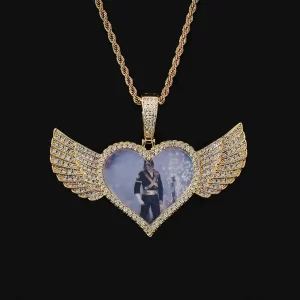 Cherish your memories with this Custom Angel Wing Heart Picture Pendant, a 75mm piece that adds both elegance and sentimentality to your collection. The Yellow Gold-plated heart is accented by angel wings, providing a special place for your cherished image. Hypoallergenic, waterproof, and scratch-resistant, this pendant is designed for durability and daily wear. Whether as a gift or personal keepsake, the pendant combines emotional significance with high-end style, making it perfect for those who love Hip Hop jewelry with a personal touch.