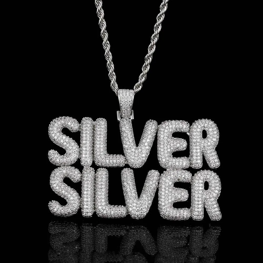 The Custom Bubble Letter Pendant in White Gold combines bold style with personal flair. Crafted in white gold plating and encrusted with VVS simulated diamonds, this oversized pendant is hypoallergenic and scratch-resistant, perfect for everyday wear or special occasions. Add your initials or favorite word to make this pendant uniquely yours, blending Hip Hop aesthetics with personal style for a standout look that’s both luxurious and meaningful.