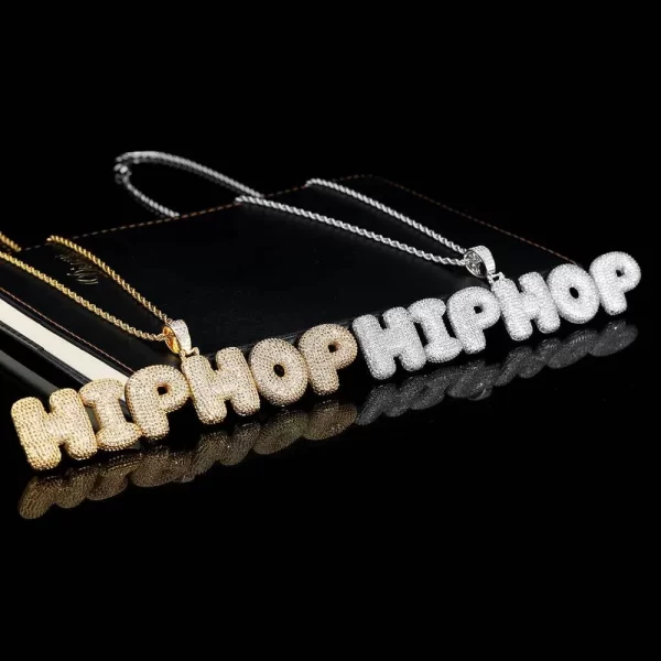 The Custom Bubble Letter Pendant in White Gold offers a sleek, modern twist on the classic letter design. Featuring bold, bubble-shaped letters in white gold-plating, it’s perfect for personalizing your look. Hypoallergenic, waterproof, and scratch-resistant, this pendant is built for everyday wear and adds a fresh Hip Hop aesthetic to any collection.