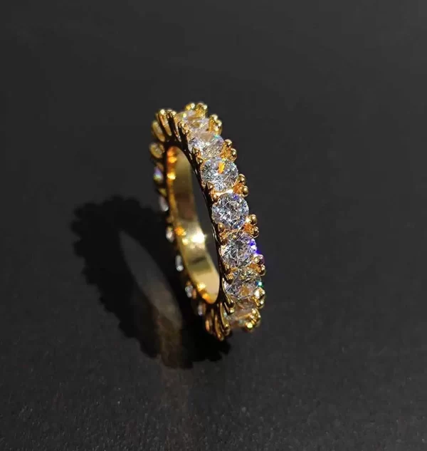 The 1 Layer Iced Prong Ring in Yellow Gold brings a sophisticated touch to your jewelry collection. With VVS Simulated Diamonds carefully set in a Yellow Gold band, this piece offers a sleek, luxurious look. The prong setting ensures each stone sparkles with maximum brilliance, making it the perfect accessory for everyday wear or special occasions. Ideal for anyone looking to elevate their Hip Hop style with elegance.